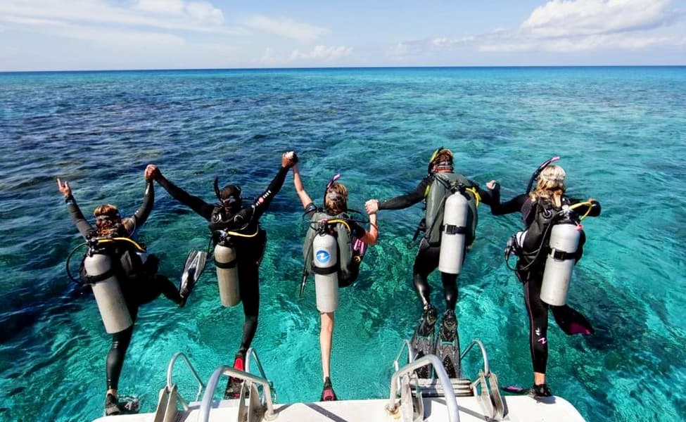 A woman and man preparing to scuba dive